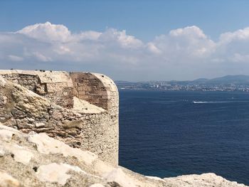 Rocks by sea against sky