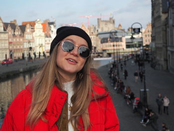 Portrait of smiling young woman standing in city