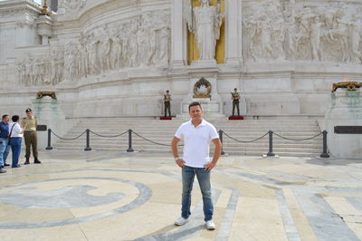 Portrait of man standing in front of historic building