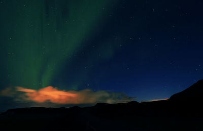 Low angle view of silhouette mountain against sky at night