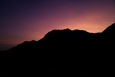 Scenic view of silhouette mountains against sky at sunset