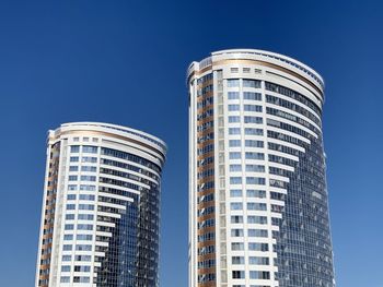 Low angle view of modern buildings against clear blue sky