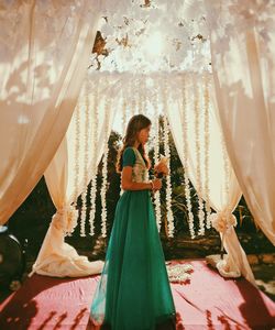 Side view of bride holding bouquet while standing at wedding ceremony