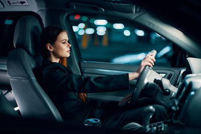 Portrait of young woman sitting in car