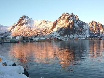 Scenic view of lake by snowcapped mountains against clear sky