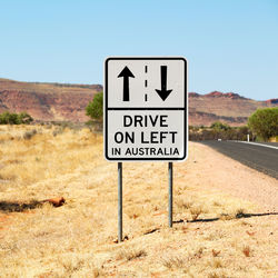 Information sign on road against sky