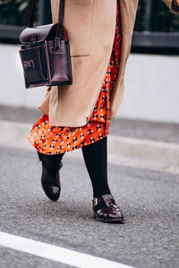 Low section of woman standing on road