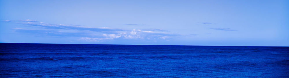 Scenic view of sea against blue sky