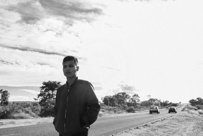 Young man standing at roadside