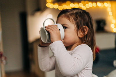 Portrait of cute girl drinking milk while sitting at home