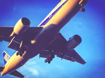 Low angle view of airplane against clear blue sky