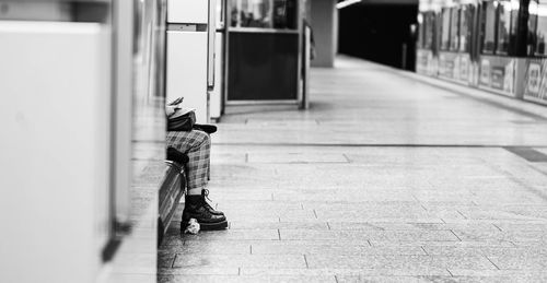 Rear view of man sitting on footpath