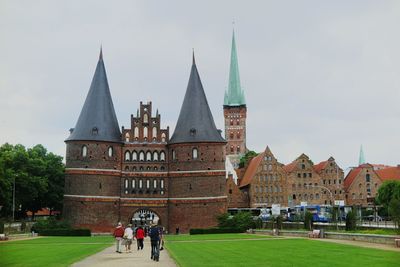 People in town square against sky in city