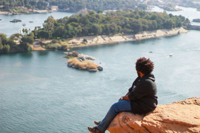 Man sitting on cliff by nile river