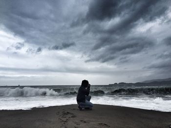 Scenic view of beach against cloudy sky