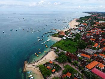 High angle view of sea and cityscape against sky