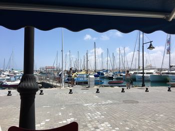 Sailboats moored in harbor against sky