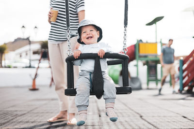 Portrait of boy swinging at playground