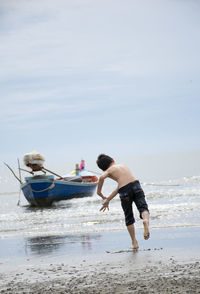 Men on beach against sky