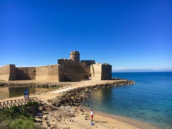 View of fort on beach against clear blue sky