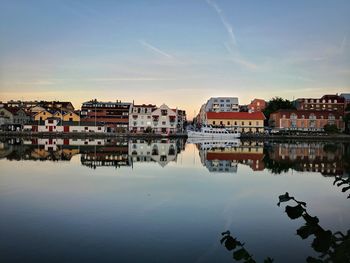 Reflection of buildings in river against sky