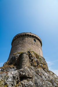 Low angle view of old ruin against clear blue sky