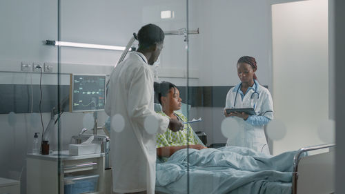 Doctor discussing with patient over tablet pc in hospital