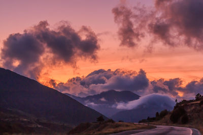 Red sunset in the mountains with big white clouds. clouds concept