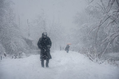 Rear view of people walking on snow covered land