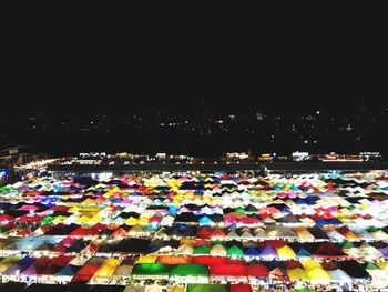 Multi colored illuminated city against sky at night