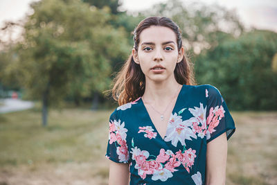 Portrait of woman standing against tree