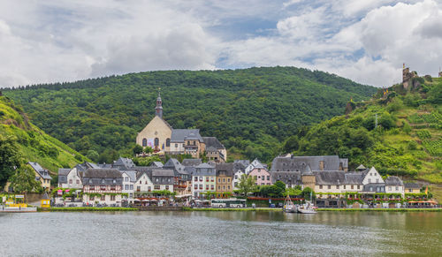 Scenic view of lake by buildings against sky