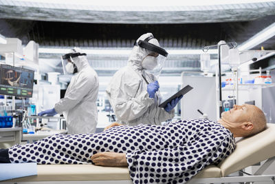 Side view of female friends standing in factory