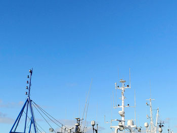 Low angle view of communications tower against clear blue sky