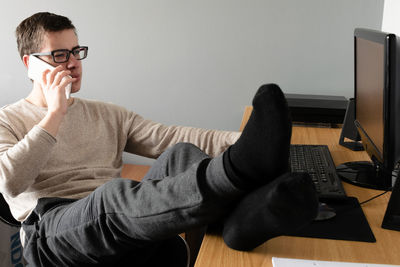 Man using mobile phone while sitting on table