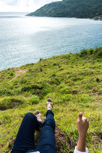 Low section of person relaxing on lakeshore