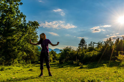 Full length of woman standing on field against sky