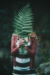 Woman holding fern leaf