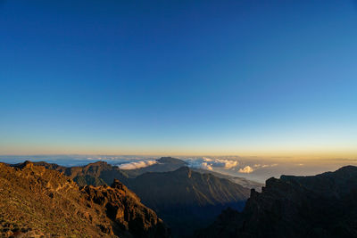 Panoramic view of mountain range against blue sky