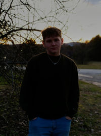 Portrait of young man standing on field