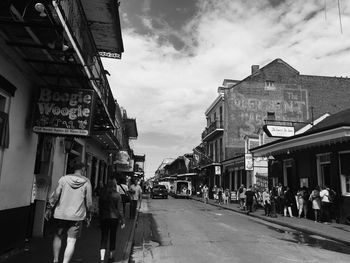 People walking on street amidst buildings in city