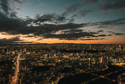 High angle view of illuminated city against sky during sunset