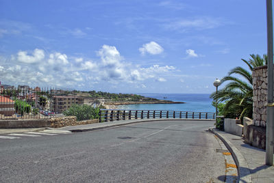 Road by sea against sky in city