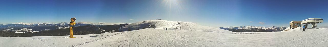 Scenic view of snow covered mountain against blue sky