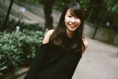 Portrait of smiling young woman standing outdoors