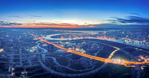 High angle view of illuminated cityscape against sky during sunset