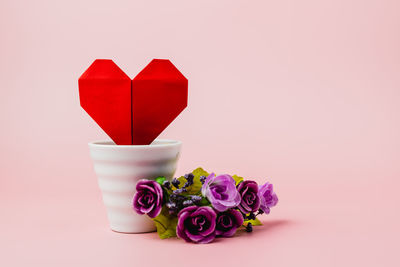 Close-up of red flower on table against white background