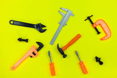 High angle view of work tools against yellow background