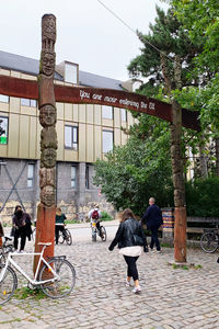 People walking on sidewalk by building in city