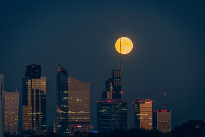 Illuminated buildings against sky at night